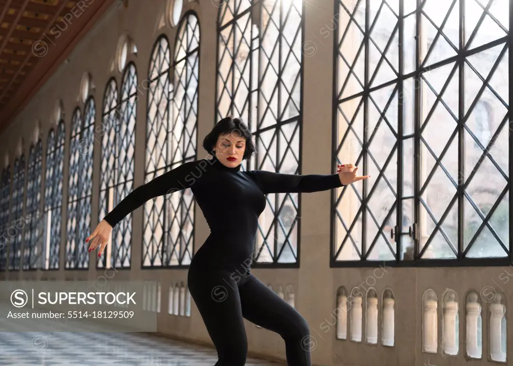 Graceful woman dancing in ballroom