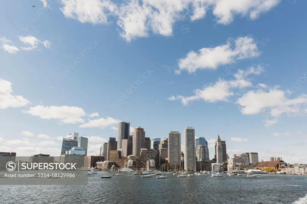 View of Boston City Skyline from offshore against blue sky