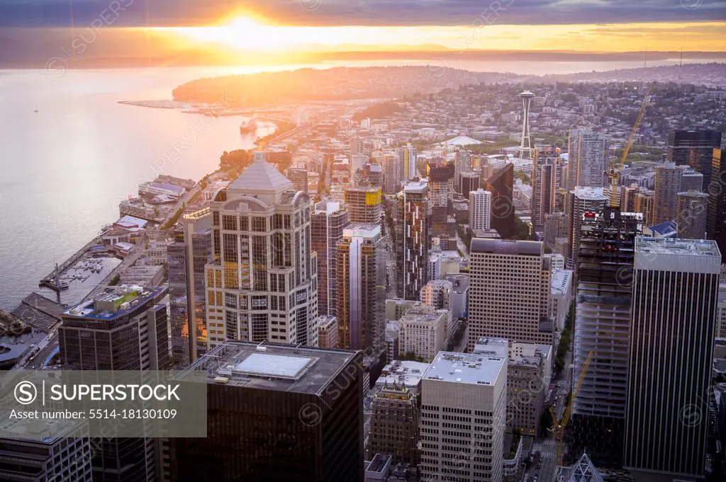 Seattle Skyline At Sunset With Sun Peaking Through The Clouds