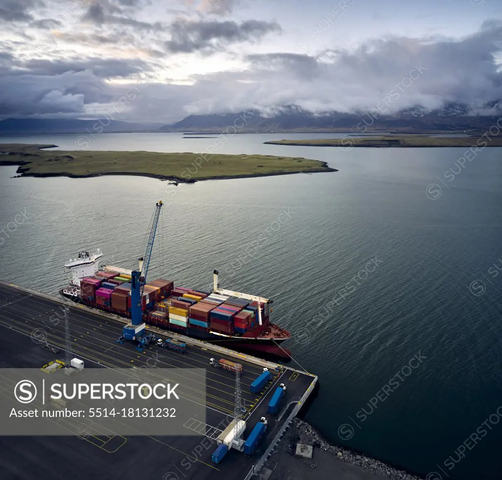 Sea wharf with cargo ship under clouds