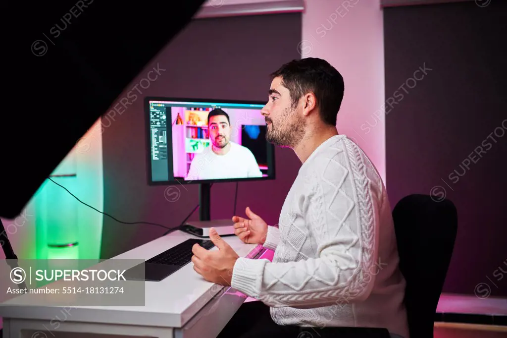 Young fat streamer on a room with multicolor lights