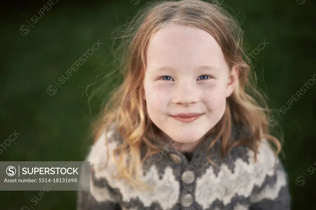 Happy freckled girl looking at camera