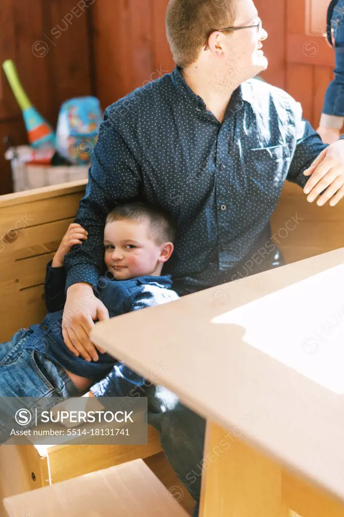 A father holding his son in his arms while watching his other boy