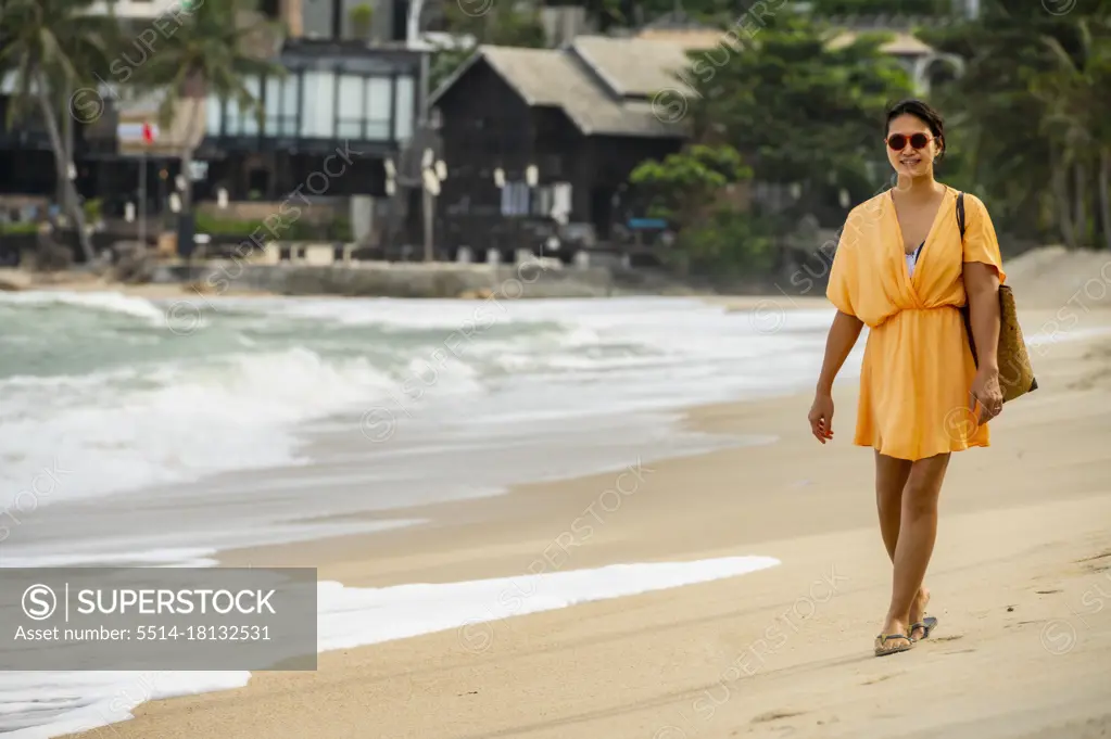 Woman walking along the beach on the tropical island of Koh Phangan