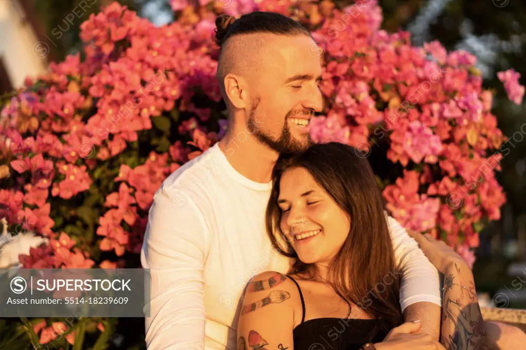 couple in love among flowers hugs and laughs