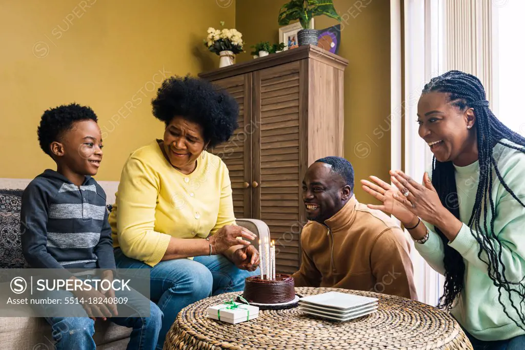 Cheerful multi-generational family celebrating birthday at home