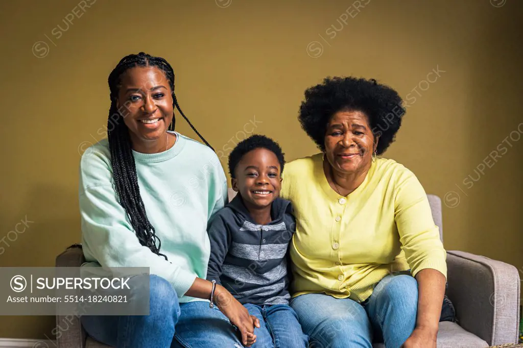 Portrait of smiling boy with mother and grandmother at home