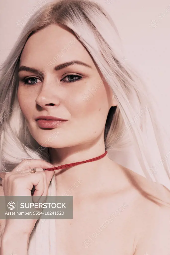 Studio Fashion Portrait Of Blonde Wearing red choker topless.