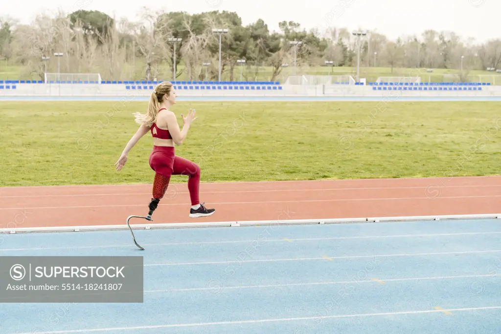 Strong handicapped athlete running on stadium