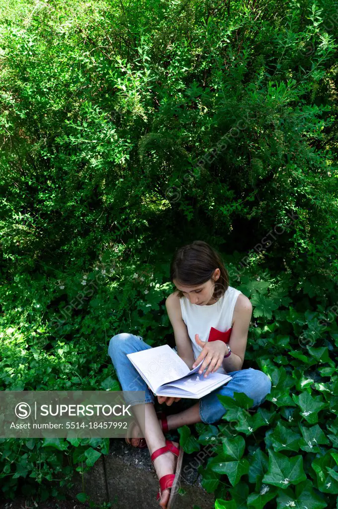 girl reading a book in the garden