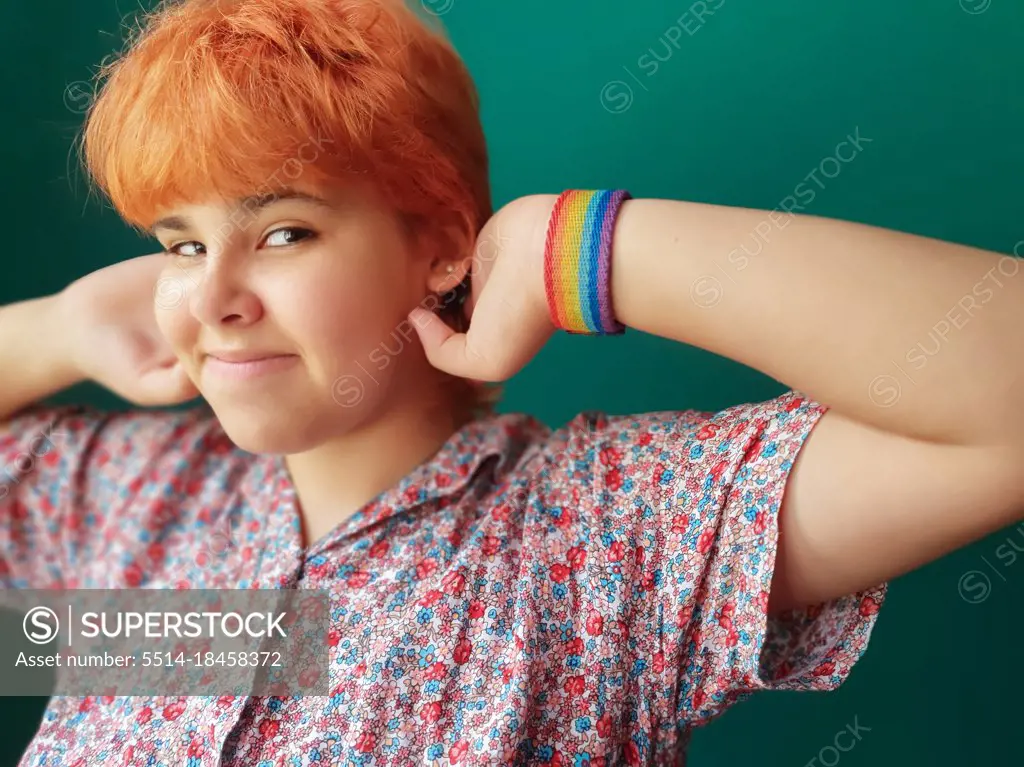 Red hair teenager girl with a LGTB bracelet looking at camera proudly