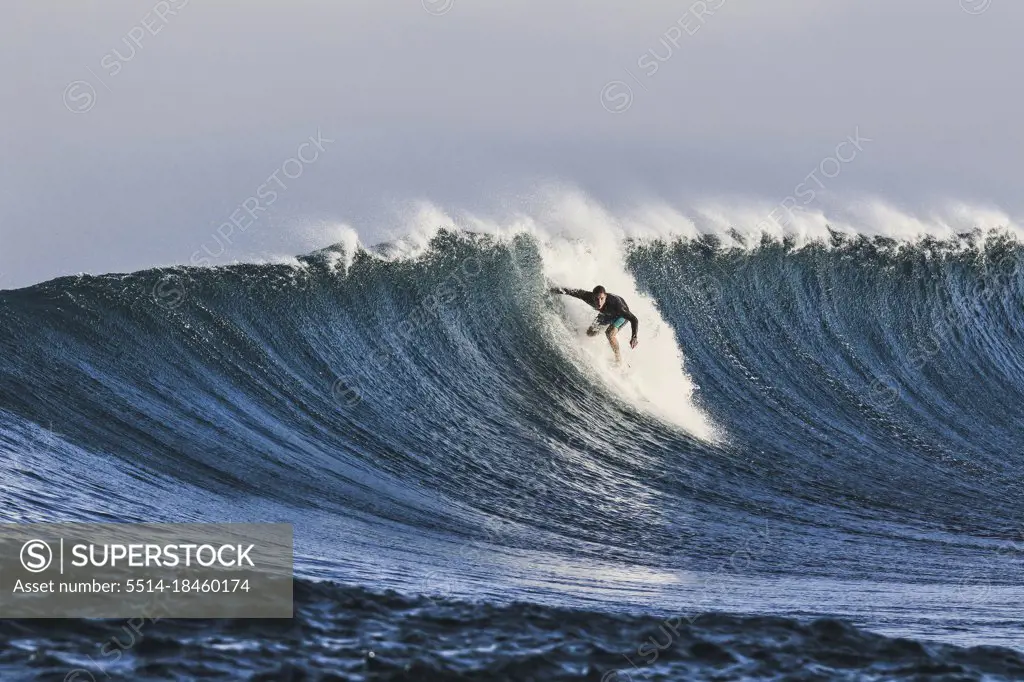 Surfer on a blue wave at sunny day