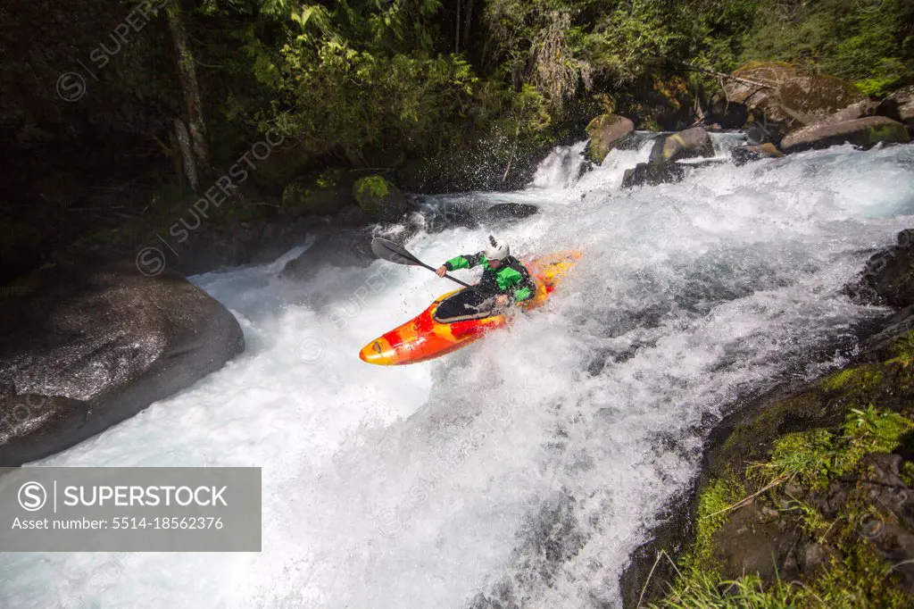 Whitewater kayaking off a small waterfall