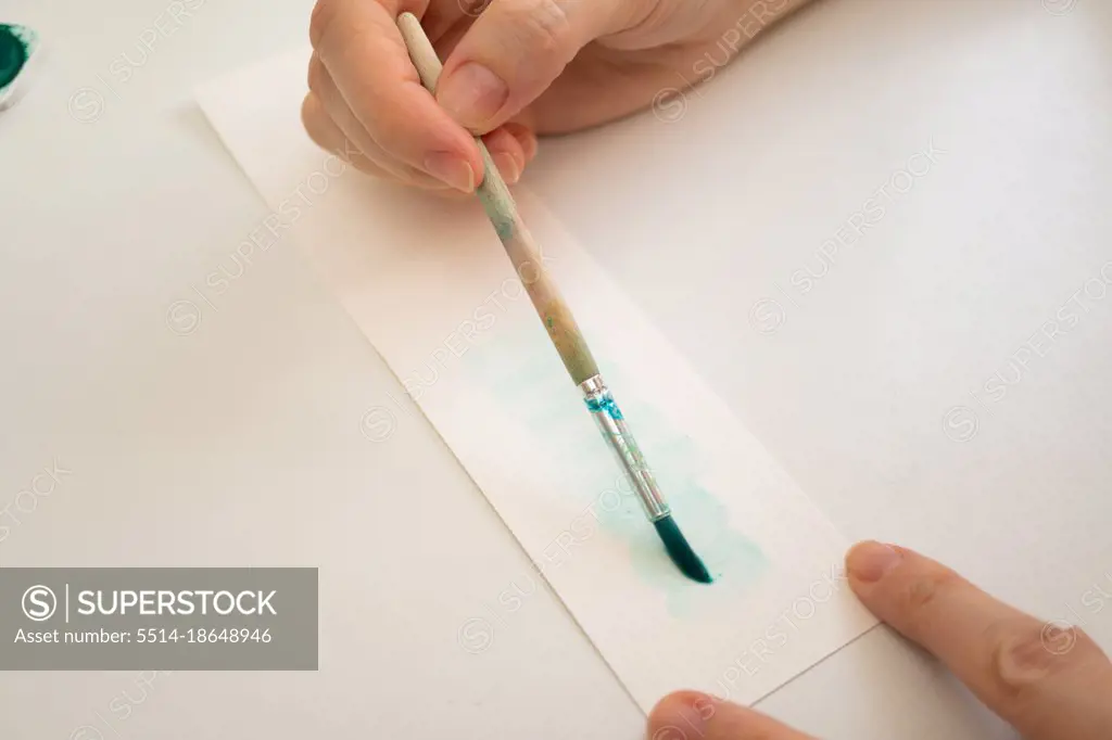 woman painting with watercolors in her studio at home