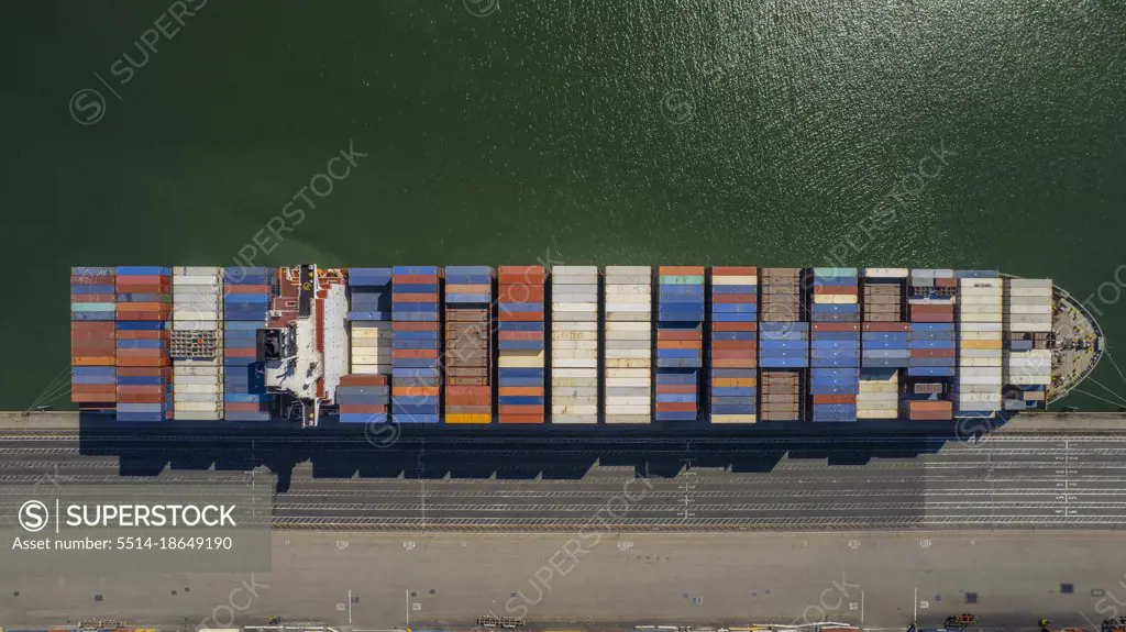 Aerial view of a fully loaded cargo ship docked at a port