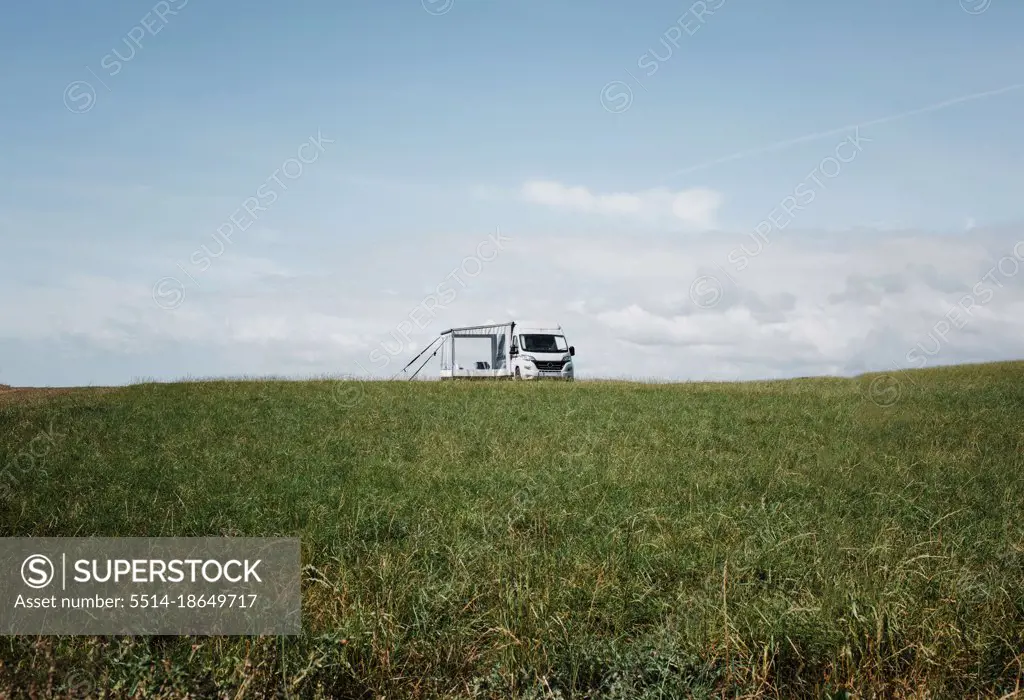 camper van alone in a large green open field in England