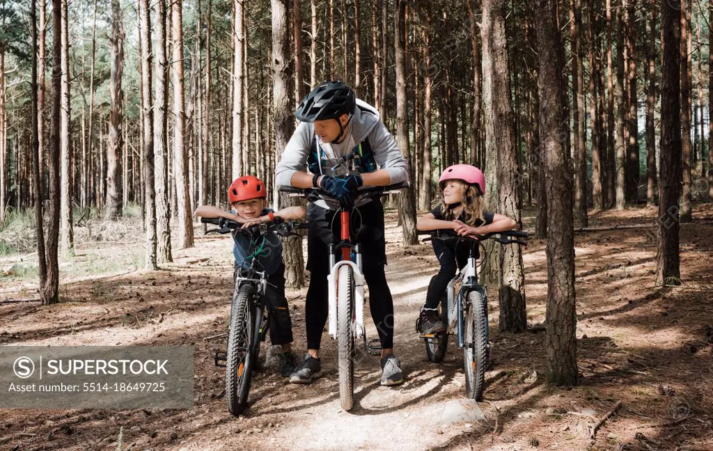 dad and his kids enjoying a bike ride in the forest