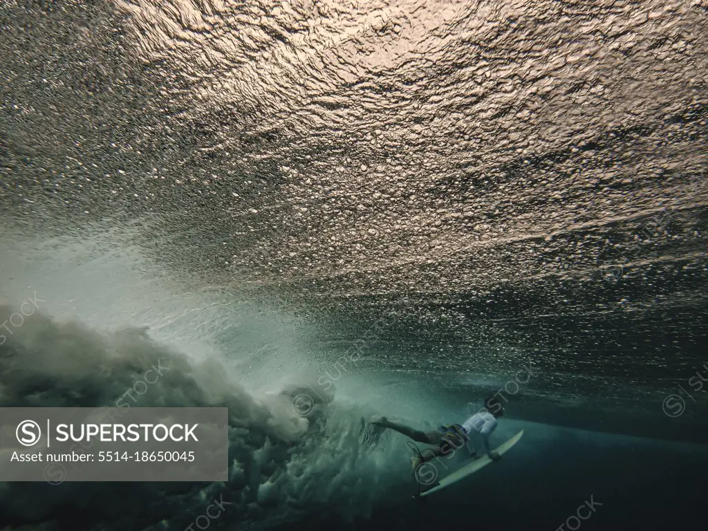 Surfer on surfboard, underwater view