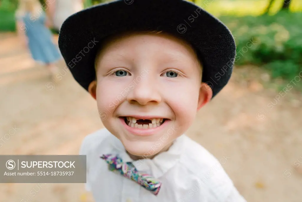 Closeup portrait of a young boy smiling with two missing front teeth