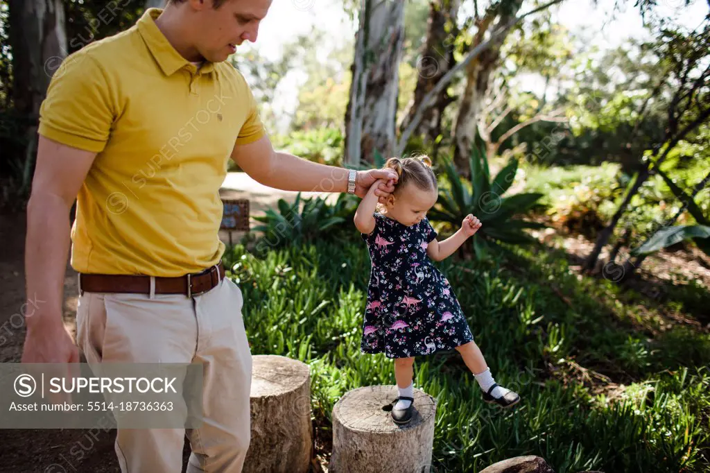 Dad Holding Daughter's Hand in Garden in California