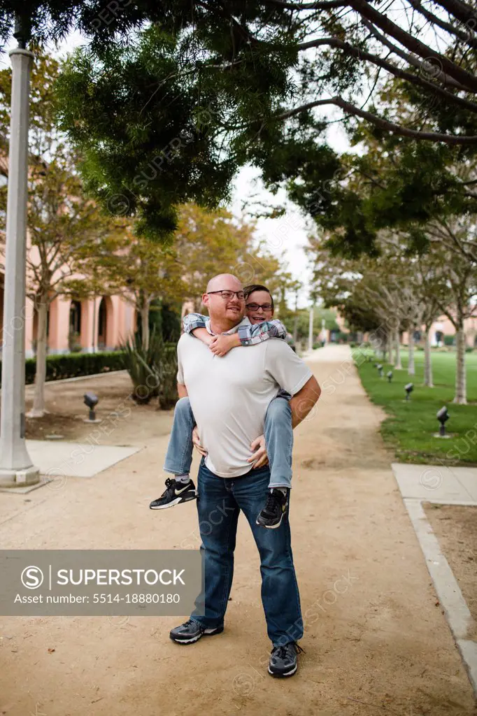 Dad Giving Ten Year Old Son a Piggyback Ride in San Diego