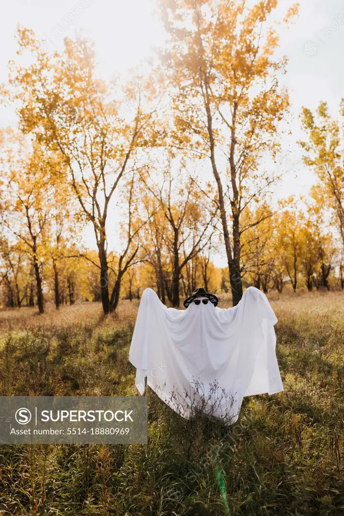 Full body image of person dressed as ghost looking at camera