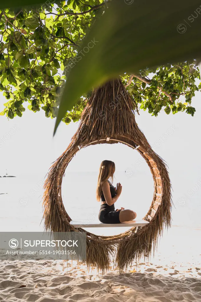 woman doing yoga on bamboo estructure