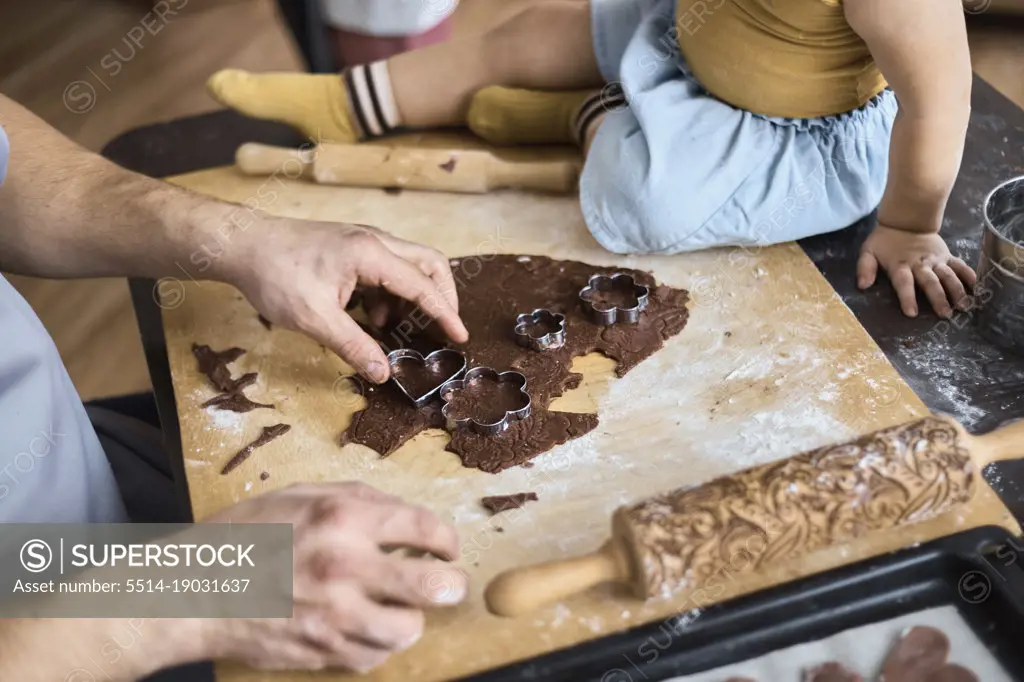 Dad cuts out chocolate chip cookies with a mold