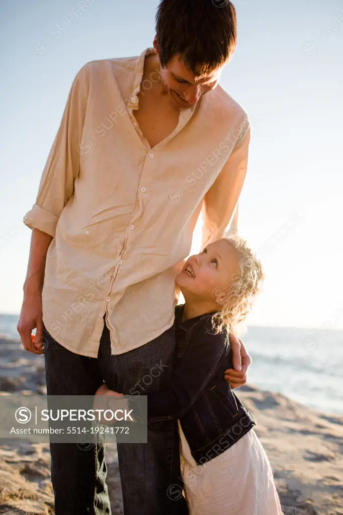 Daughter Grabbing Dad's Leg on Beach at Sunset in San Diego