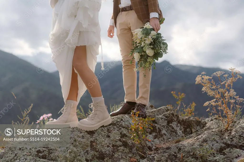 Legs of the bride and groom in wedding dresses