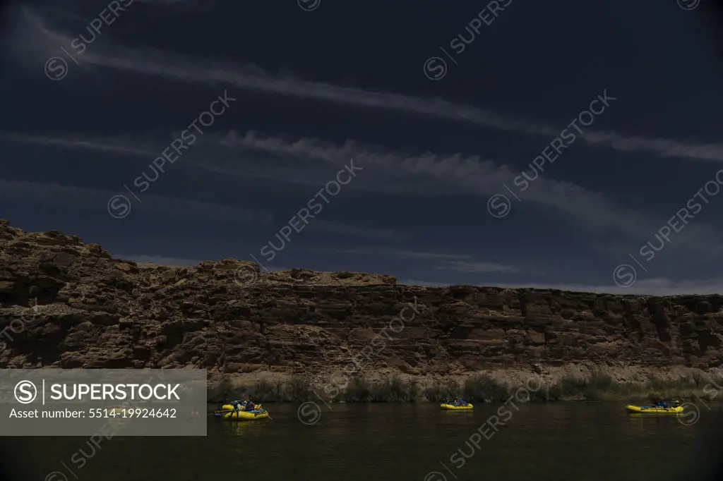 5 rafts floating down the Colorado River in the Grand Canyon