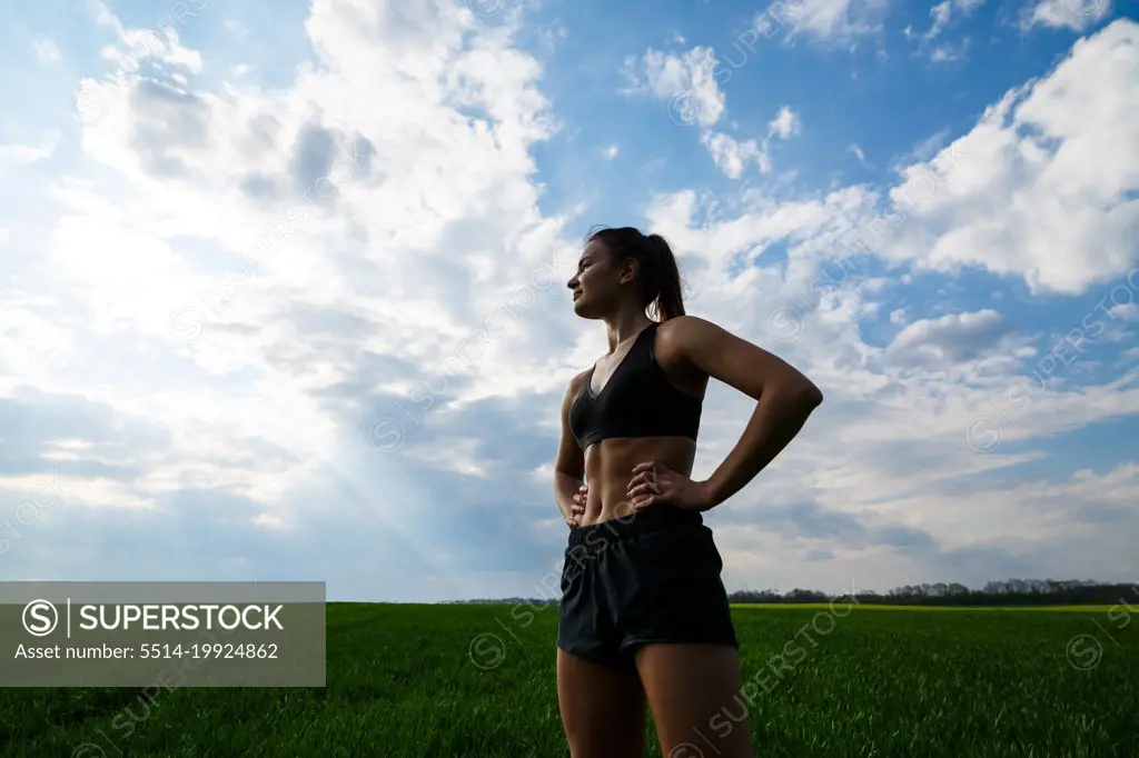 Girl athlete does warm-up outdoors, exercises for muscles