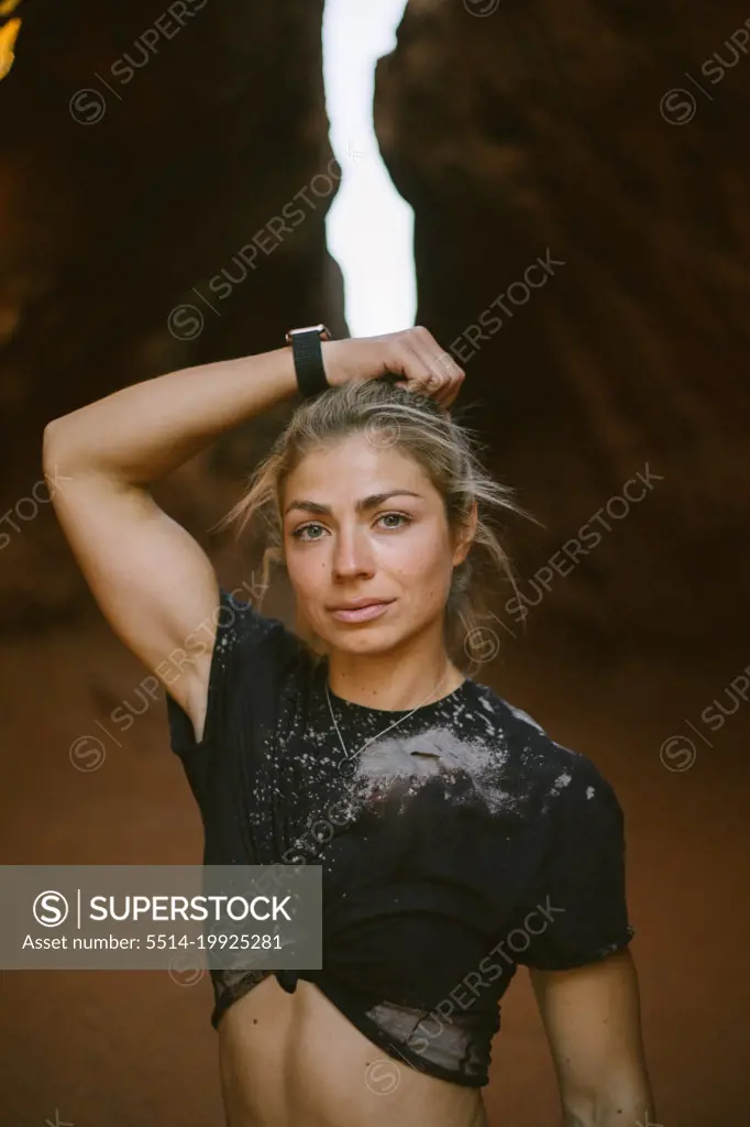 Fit happy woman walking through orange rock in the desert wearin