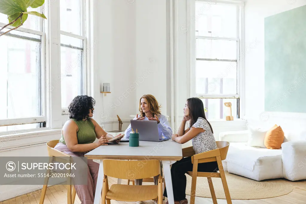 Multiracial businesswomen discussing business strategy at table