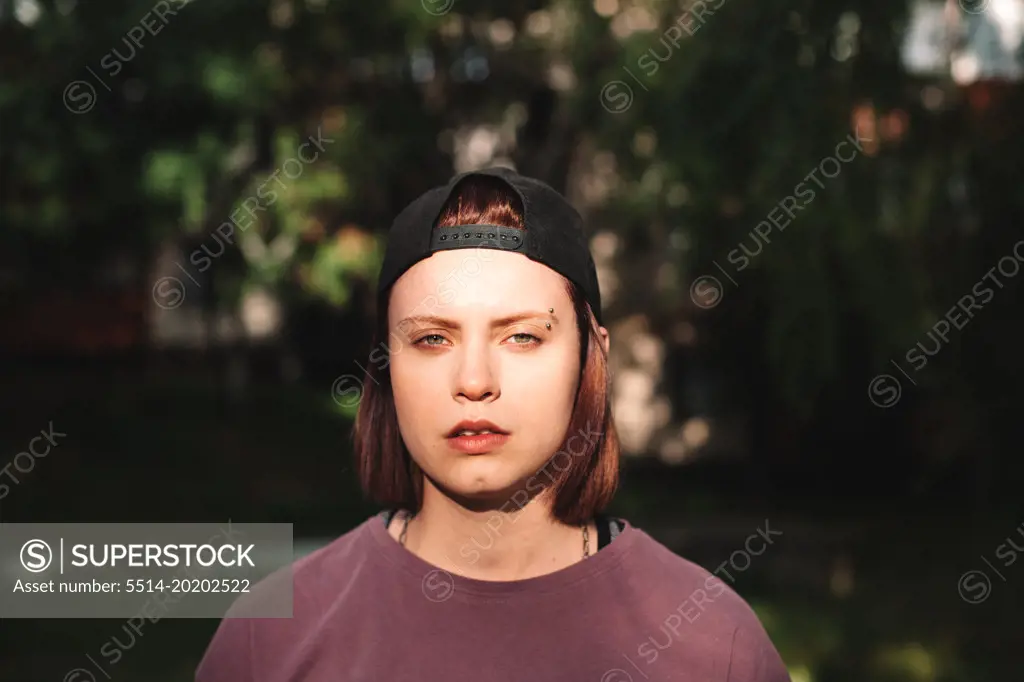 Portrait of punk teenage girl with pierced eyebrow outdoors