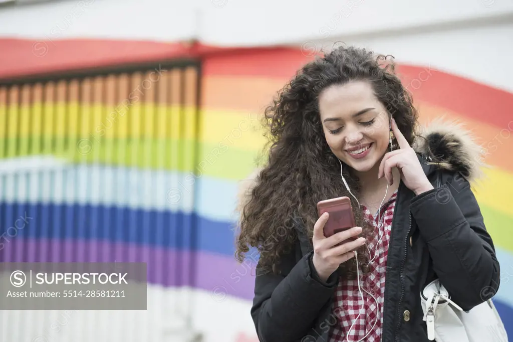 University student listening to music in front of graffiti wall School, Bavaria, Germany