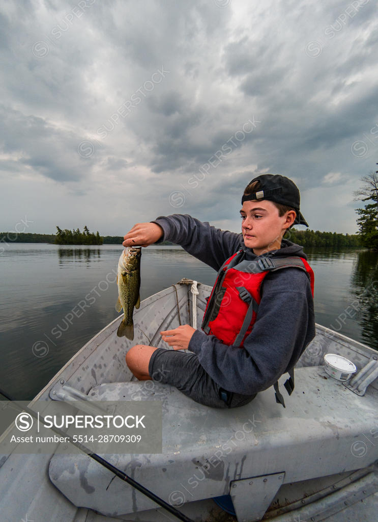 Teen boy showing a fish he caught — Stock Photo © michaeljung #10515682