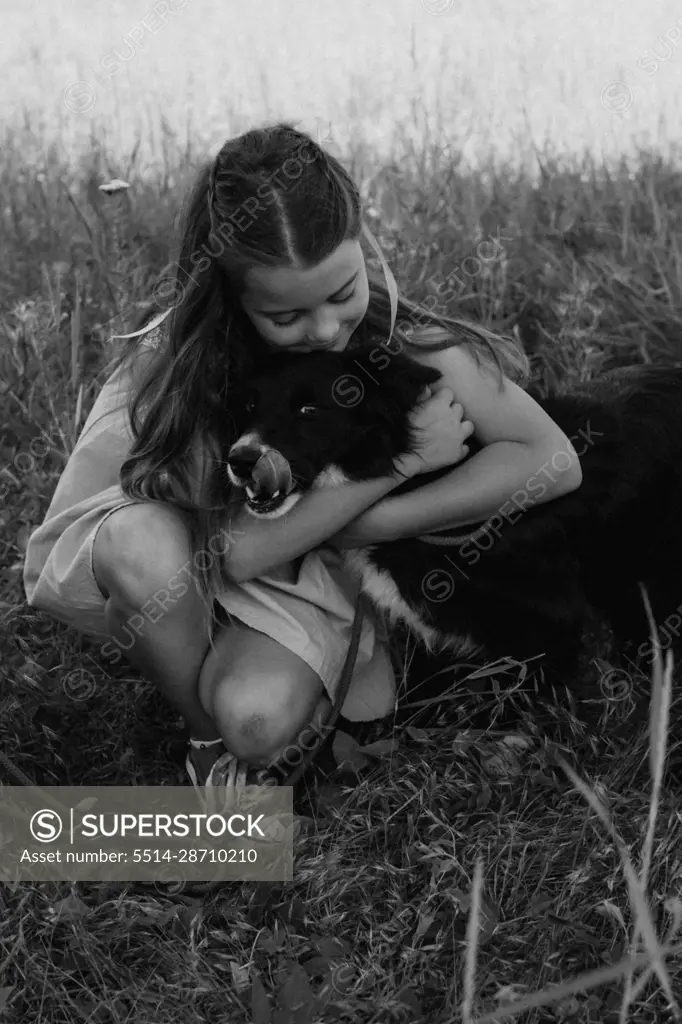 Happy girl hugging her dog outdoors. Lifestyles and pet care concept.