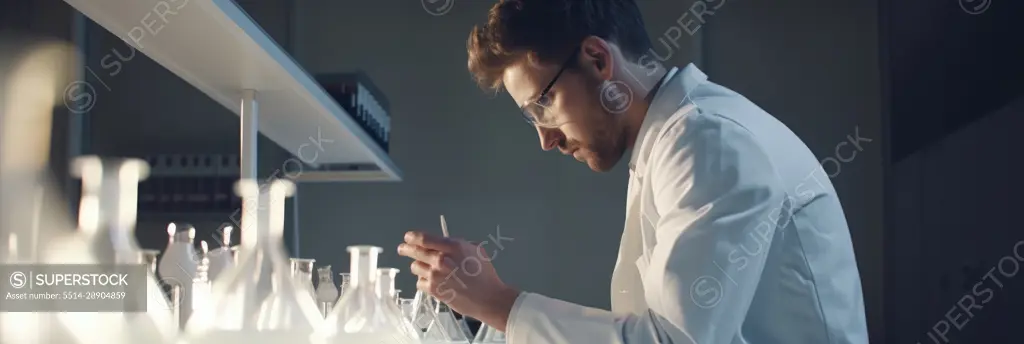 Young caucasian male scientific in working in lab. Generative AI.