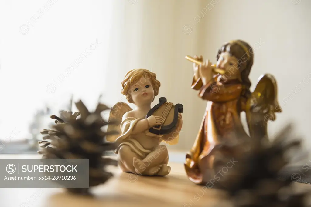 Decorative Christmas angel figurines with musical instruments and pine cone on the table, Bavaria, Germany