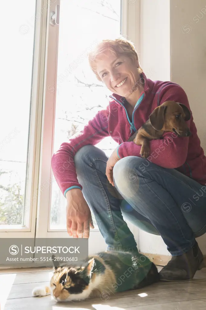 Mature woman with her pets at home, Bavaria, Germany