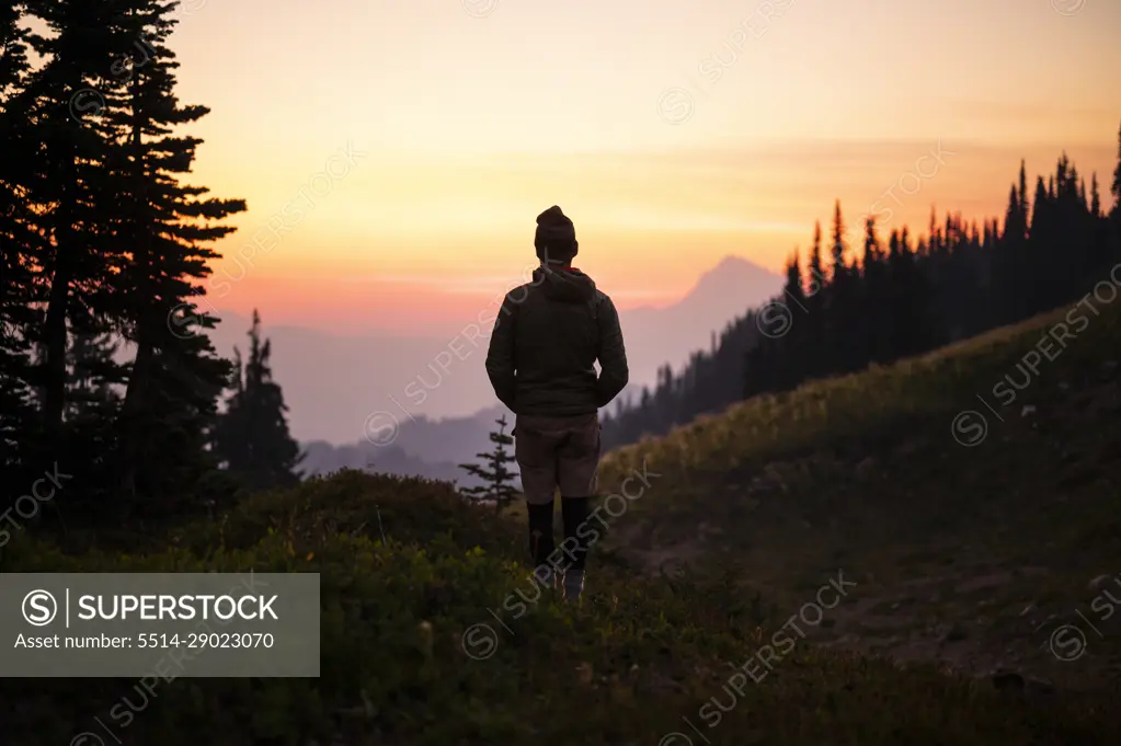 Silhouette of male watching colorful sunset in the cascade mountains