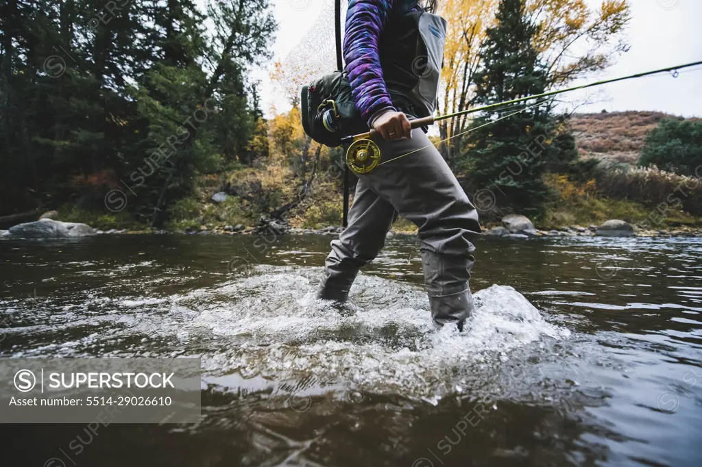 Midsection of woman fly fishing at Roaring Fork River