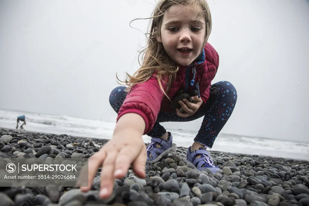 Young Girl Searches for Skipping Rocks