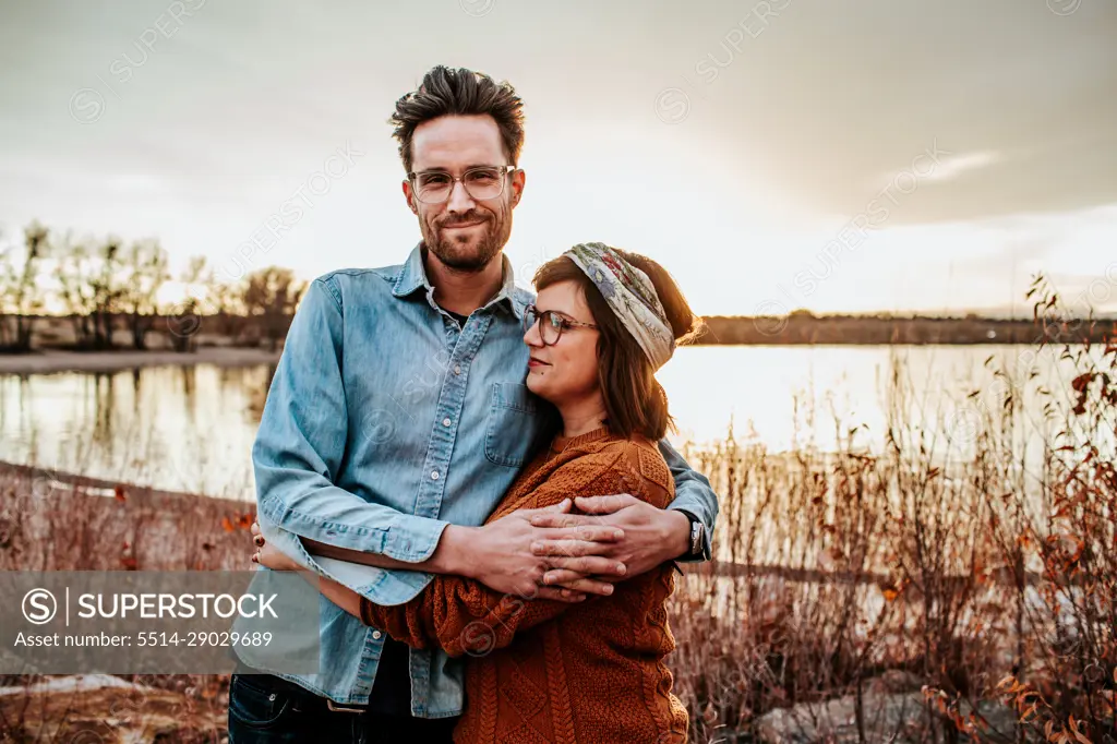 Happy couple hugging near a lake in Denver CO on a autumn evening