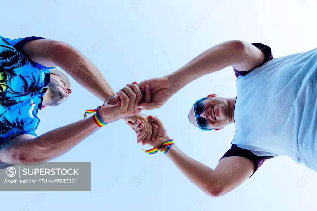 Gay couple holding hands while enjoying their vacation.