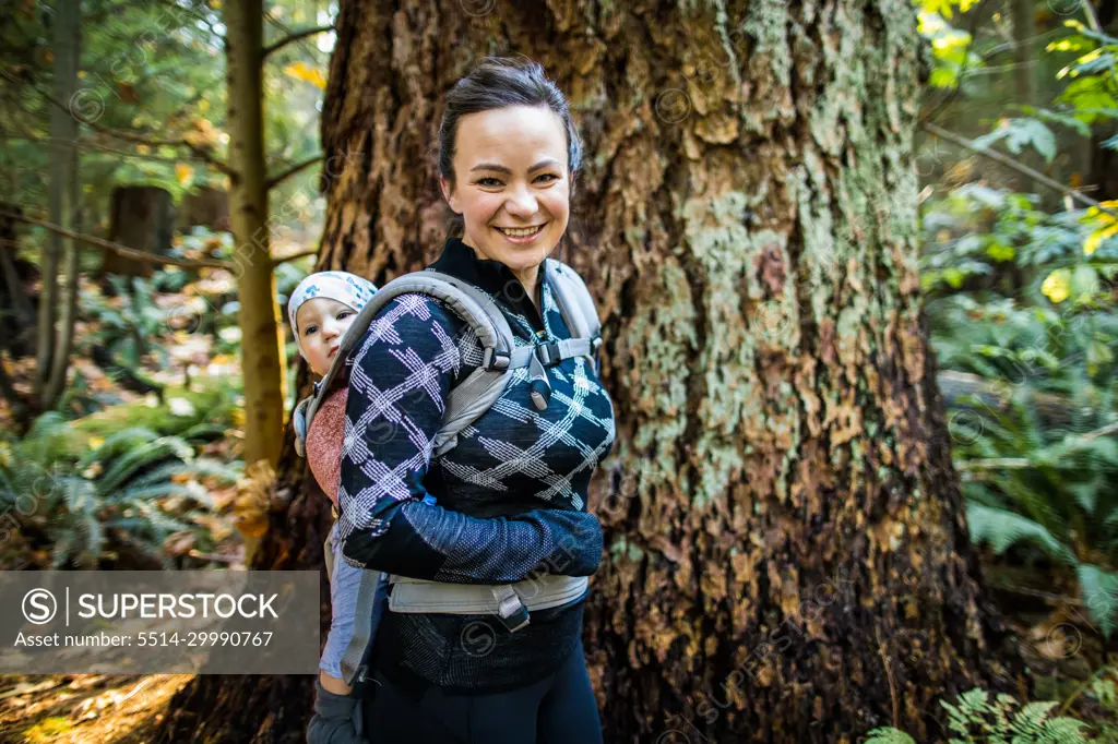 Healthy and fit mother wearing baby carrier, hiking