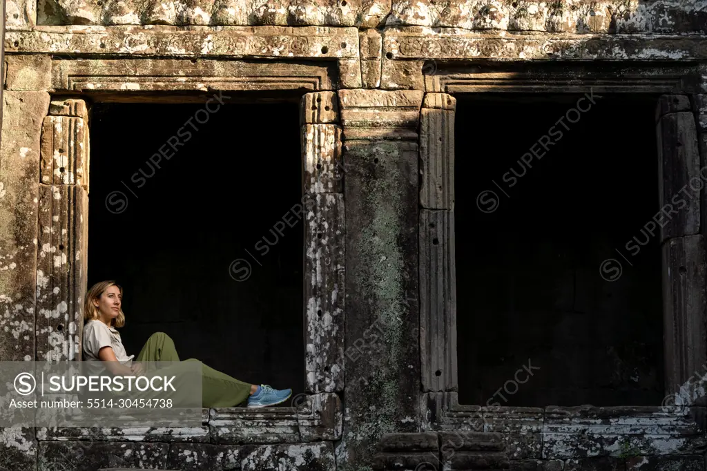 tourist woman looking from a picture window illuminated by the d