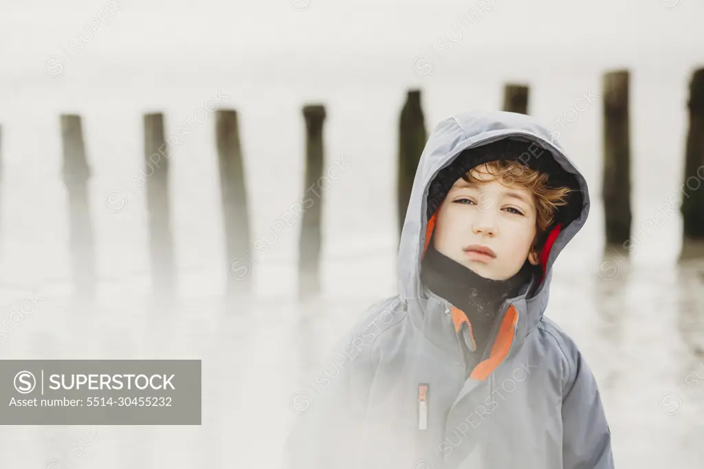 Portrait of cold boy on beach in winter