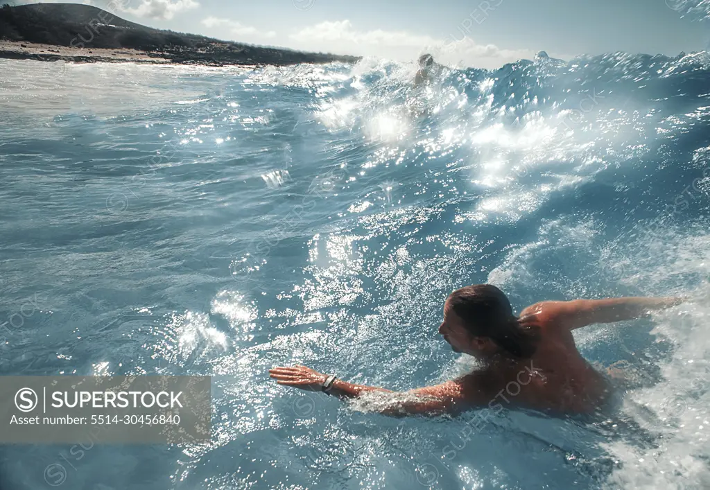 swimmer body surfs in hawaii